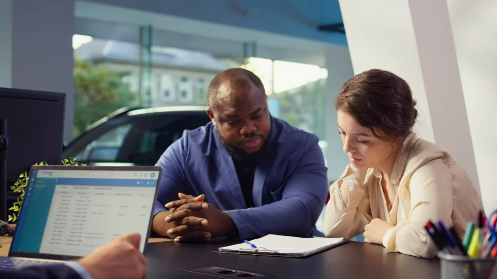 A couple reviewing policy documents and comparing non-life insurers in Bangladesh before switching car insurance