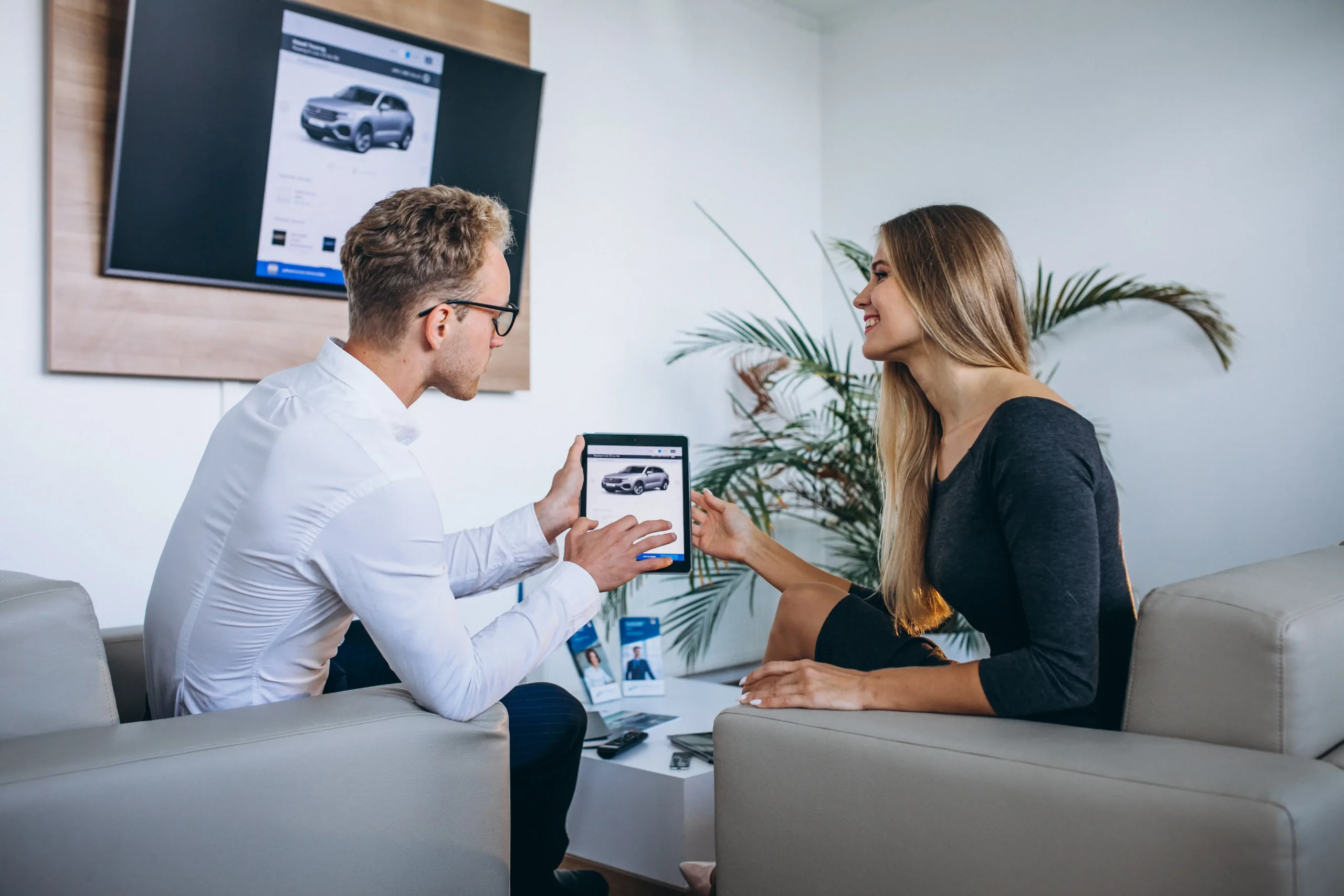 An insurance representative showing policy options on a tablet to a customer learning how to switch car insurance companies in Bangladesh
